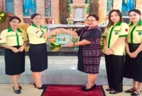 Ketua Pemuda Katolik Komcab Rote Ndao, Ida Farida Jemida didampingi pengurus menyerahkan secara simbolis dua unit tong sampah kepada Ketua 2 DPP St. Kristoforus Ba'a, Ny. Maria Stefana Thius, di Parokis Kristoforus Ba'a, Minggu (23/11/2025). | FOTO/ist.