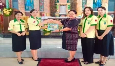 Ketua Pemuda Katolik Komcab Rote Ndao, Ida Farida Jemida didampingi pengurus menyerahkan secara simbolis dua unit tong sampah kepada Ketua 2 DPP St. Kristoforus Ba'a, Ny. Maria Stefana Thius, di Parokis Kristoforus Ba'a, Minggu (23/11/2025). | FOTO/ist.