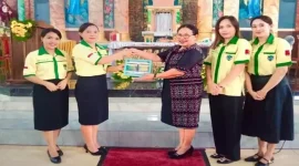 Ketua Pemuda Katolik Komcab Rote Ndao, Ida Farida Jemida didampingi pengurus menyerahkan secara simbolis dua unit tong sampah kepada Ketua 2 DPP St. Kristoforus Ba'a, Ny. Maria Stefana Thius, di Parokis Kristoforus Ba'a, Minggu (23/11/2025). | FOTO/ist.